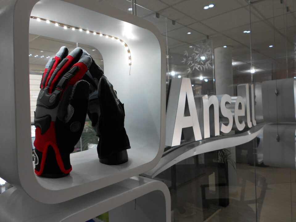Estante suspendido con iluminación integrada para exhibición de productos en recepción de Ansell México
