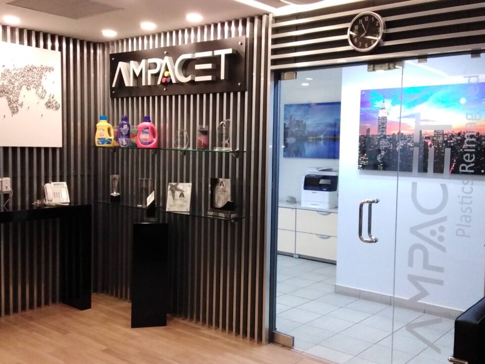 Diseño de recepción corporativa con revestimiento de tiras de aluminio para AMPACET